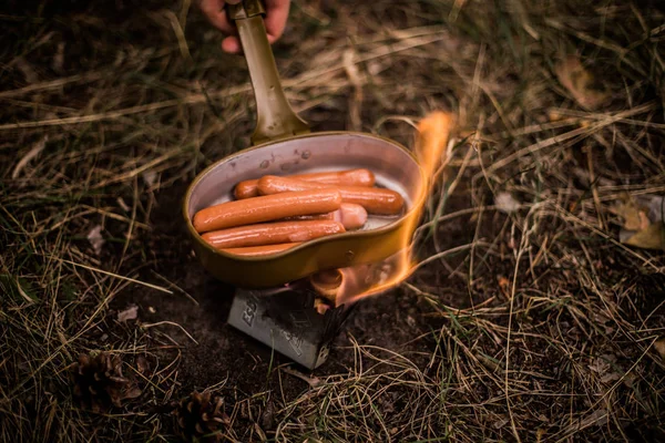 Sausages fried in a pan of a military pot