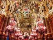 Interiér paláce Garnier Opera a zlatý malovaný strop s mnoha hangining lustry v Paříž, Francie.