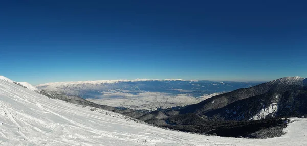 ブルガリアのバンスコ市にピリン山脈の頂上からパノラマ ビュー 冬の寒い日 雪に覆われたピーク 澄んだ青い空 — ストック写真