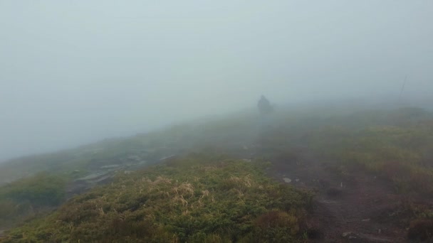 流浪者像陌生人一样在丘陵路上行走 在寒冷的大风天爬山 风在吹云 薄雾在移动 — 图库视频影像