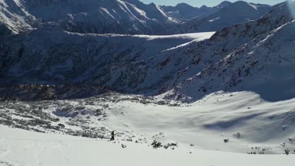 冬の雪山でスキーをする男性 晴れた日に青空の風景スキーコース ピリンは氷河と岩の斜面の美しい景色をピーク — ストック動画