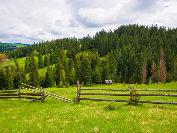 Pintoresca escena de montañas de primavera con valla de riel dividida de madera — Foto de Stock