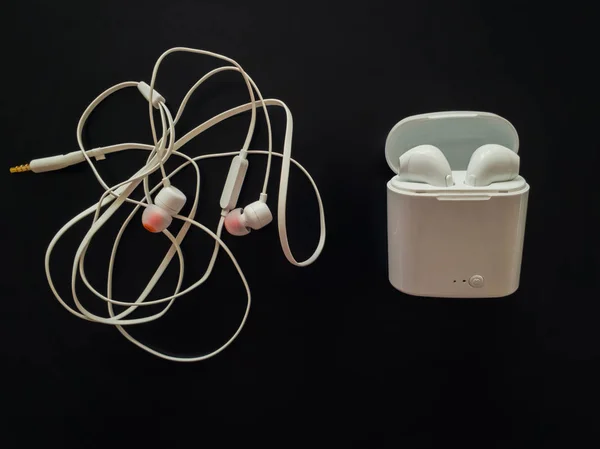 Comparison between tangled wired headphones versus wireless earp — Stock Image Comparison between tangled wired headphones versus wireless earp Stock Picture