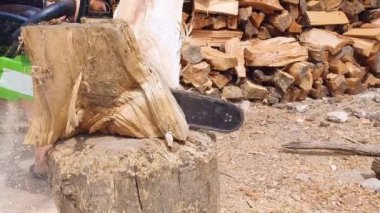 Onun Chainsaw kullanarak günlükleri için ahşap kesme oduncu veya Logger eller kapatın. Ağaç kesici çalışma ve talaş uçlarına uçmak.