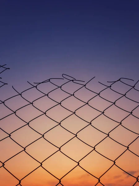 Gün batımı gökyüzü arka plan karşı eski tel örgü çit dokusu. — Stok fotoğraf