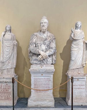 VATİKAN ŞEHRİ, Roma, İtalya - 02 Ağustos 2025 Klasik mermer heykel sakallı bir Dacian adam tipik sivri uçlu Phrygian şapkası giyen, önlüklü iki kadın heykeli ile çevrili