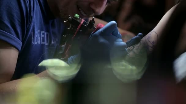 Profesionální tatér provede tetování na mans ruku v tetovací salon.