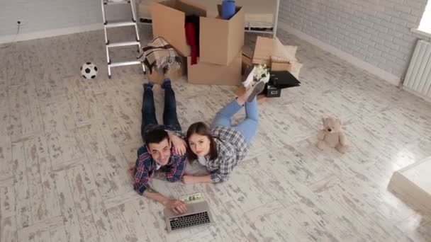 A happy couple in plaid shirts lay on