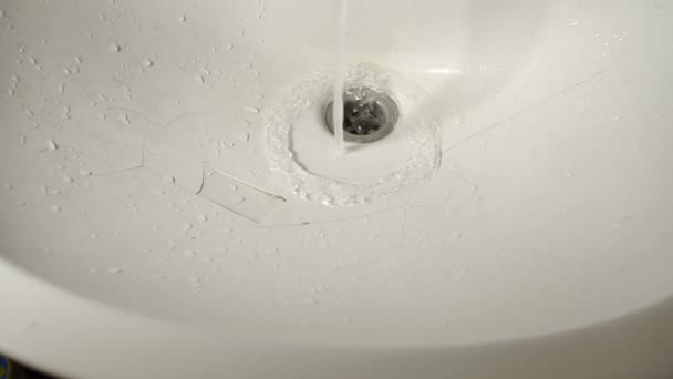 Close Up Of Water Pouring From A Tap Into A Broken Cracked Sink