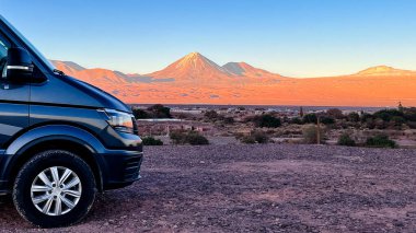 Karavan karavanı aracının ön kısmı, Şili 'nin San Pedro de Atacama çölünde kamp yaparken, arkasında kar tepesi olan Licancabur Volcano. Güney Amerika 'yı keşfeden karavan, aile, seyahat, macera