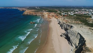 Sagres 'in batı yakasına uzanan güzel Praia do Tonel plajının insansız hava aracı fotoğrafı. Plaj devasa uçurumlarla çevrilidir ve Portekiz 'de sörf yapmak için popüler bir plajdır..