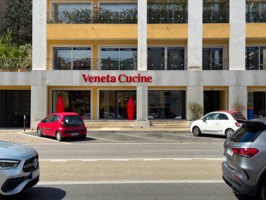 Cannes, Fransa-02.09.2025 Canlı bir sahne Veneta Cucine adlı modern bir mağazayı çekiyor, önünde parlak arabalarla dolu ve güneşli bir günde neşeli bir atmosfer ile çevrili..