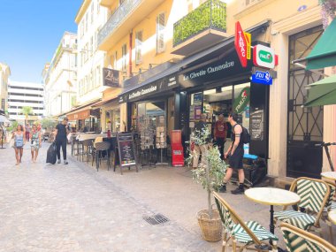 Cannes, Fransa-02.09.2025 Vibrant sokak sahnesi yayalar, rahat kafeler ve açık mavi gökyüzü altında renkli dükkanlar, sakin yürüyüşler ve rahatlama için mükemmel.
