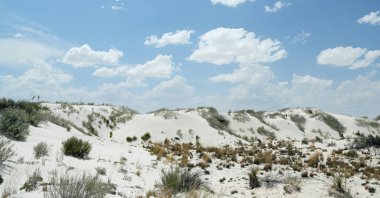 Güney New Mexico 'da bulutlar ve mavi gökyüzü ile beyaz alçı kum tepeleri