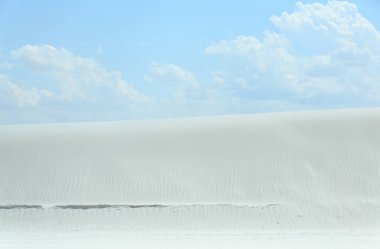 Rüzgar ile beyaz kum Dune mavi gökyüzü ve bulutlar ile bir günde dalgalanmalar oluşturuldu