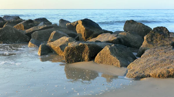 Rotsen in het zand, deel van een golfbreker — Stockfoto