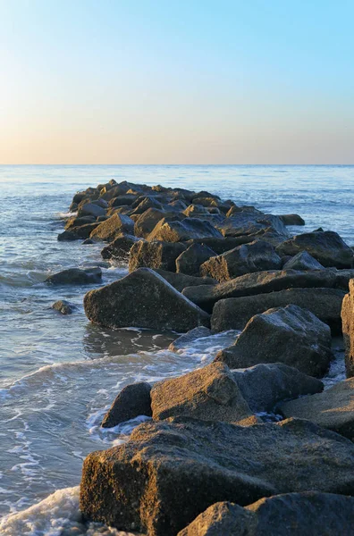 Pedras na areia, parte de um quebra-mar — Fotografia de Stock