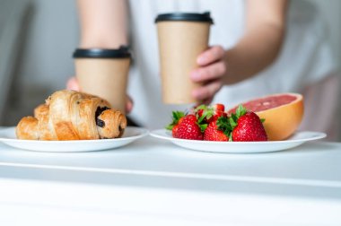 Kahvaltıda kruvasan, çilek, greyfurt ve kahve, konsept: sağlıklı ama keyifli yemek