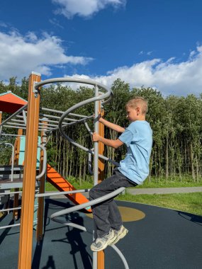 Açık hava spor parkındaki barlarda spor yapan genç bir çocuk açık bir yaz gününde spor, spor ve aktivite konsepti