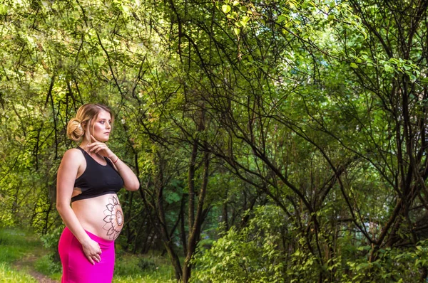 怀孕妇女与 Mehendi 在身体反对绿色树的背景 怀孕概念拍摄 — 图库照片