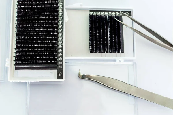 kirpik için farklı uzunlukta ve birim ve iki cımbız bir beyaz arka plan yakın çekim yapı