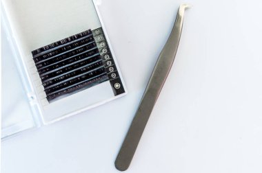 bir paket ve beyaz bir arka plan üzerinde bir yordam için cımbız tırmanan için kirpik