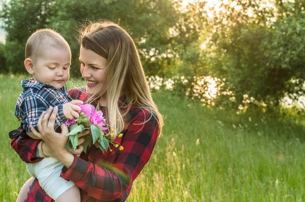 buket çiçek ile anne ve oğlu Park portresi. pembe peonies