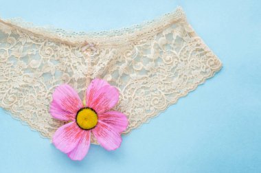 mavi bir arka plan üzerinde bej dantel külot. bekaret kavramı