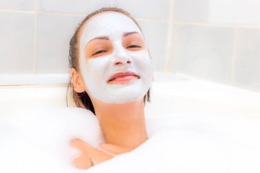 Yüzünde bir maske ile genç kadın banyoda yatıyor.