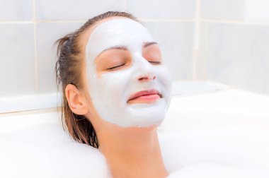 Yüzünde maske olan kadın kapalı gözler banyo yer almaktadır. Yüz yakın çekim