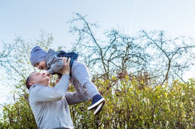 Baba oğlu onun kollarında tutar. kavram babalar günü