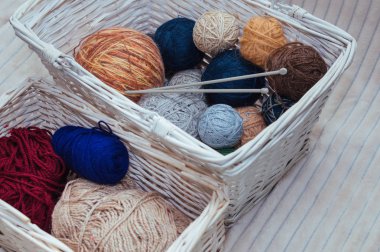 İplik ve örme iğneler beyaz sepet içinde renkli topları. İplik ve örme için aksesuarlar kavramı depolama.