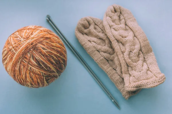 Large tangle of thread with knitting needles inside and winter mittens beside. Concept sewing and creativity.