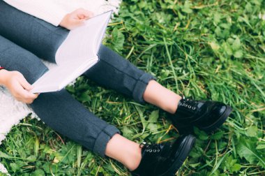 Kız beyaz ekose Park'ta bir kitap okuma