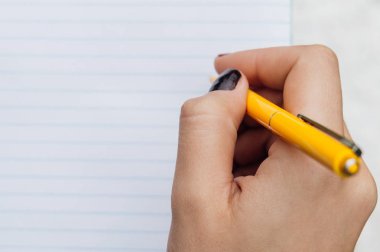 Kadın el Sarı kalem ve bir ticker closeup içinde boş sayfa