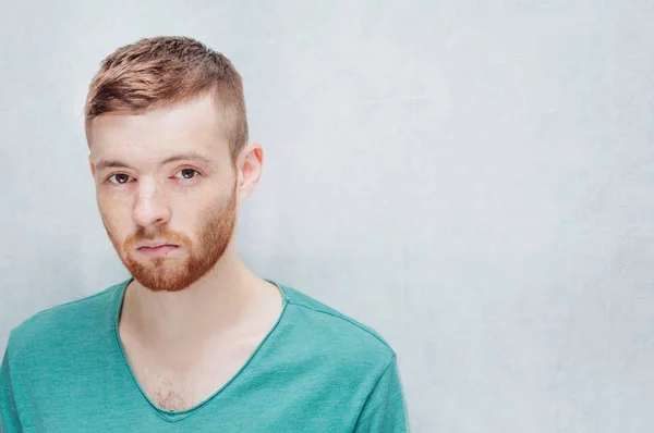 Man with a sad facial expression on a gray background