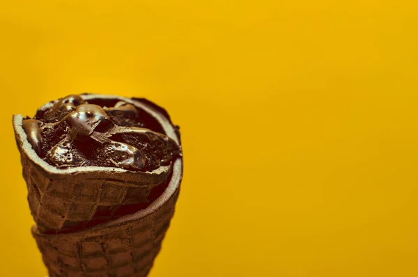 Black ice cream on a yellow background. Toning. Trend