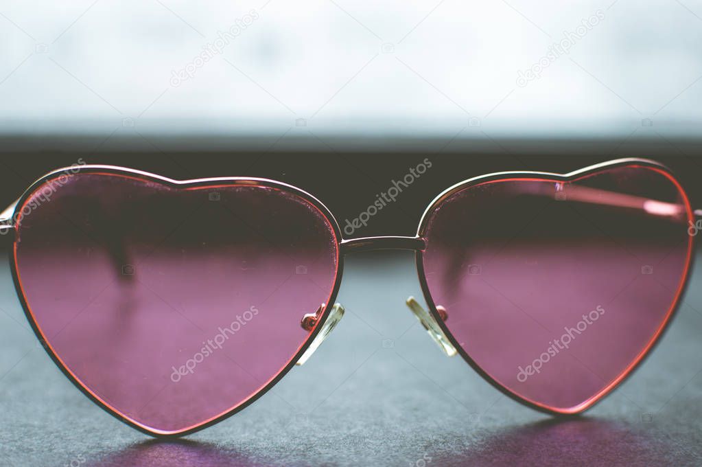 Pink heart-shaped glasses closeup. Concept love