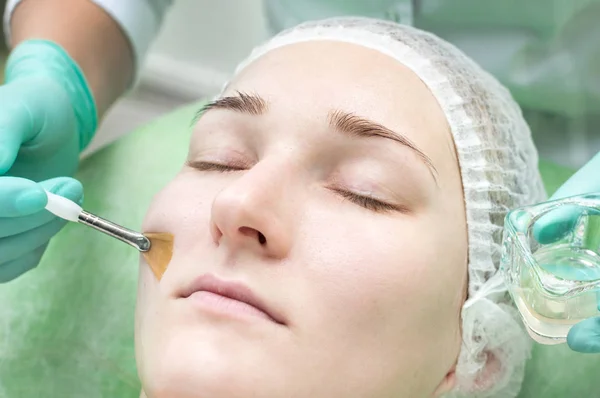 Facial peeling from a beautician in a beauty salon. Close-up face.
