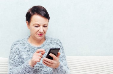 Bir smartphone internetten kadın kıdemli portresi kullanır