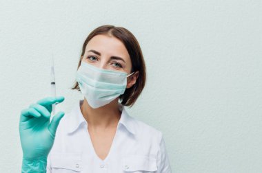 Genç kadın doktor bir şırınga elinde tutar. Grip kavramı