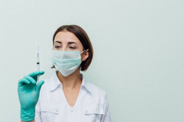 Genç kadın doktor bir şırınga elinde tutar. Aşılama kavramı