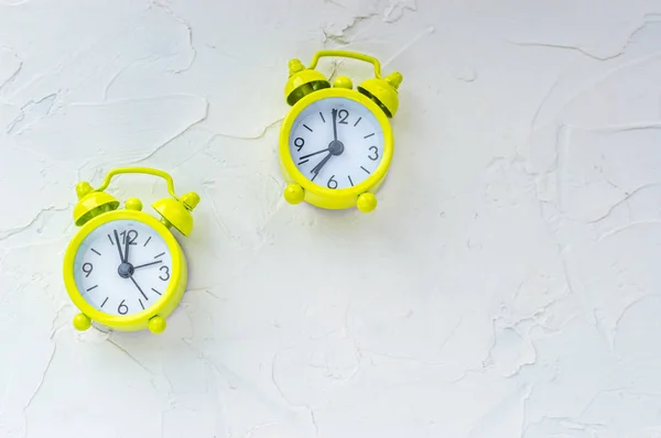 Two yellow bright alarm clock on white background. Free space. Concept get up early