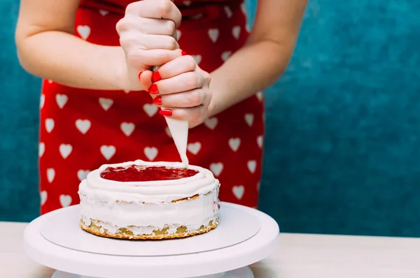 Ama de casa aplica la crema en el pastel pastel de galletas. Proceso de elaboración de pasteles. Mujer manos — Foto de Stock