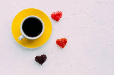 Sarı fincan kahve ve beyaz bir arka plan üzerinde kalp. Minimalizm. Kopya alanı