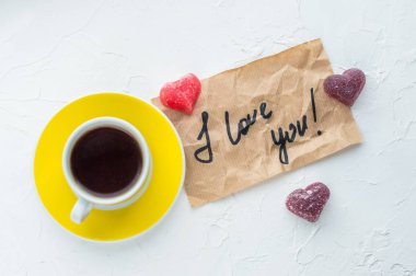 Sarı fincan kahve beyaz zemin üzerinde. Not seni seviyorum