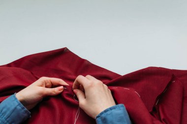 Terzi kıyafet el ile diker. Kadının ellerini kapatın. Kopya alanı