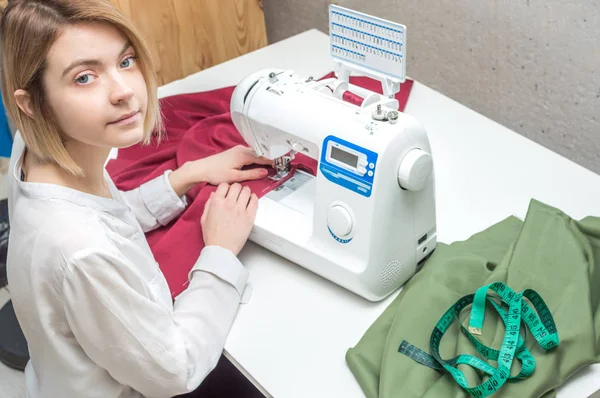 Jovem mulher costura roupas em uma máquina de costura. Retrato de close-up — Fotografia de Stock