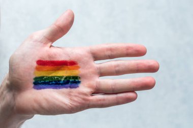 Gökkuşağı bayrağı Palm'da bir adam. Kavramı sembol Lgbt