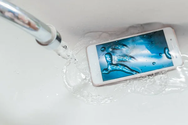 Smartphone dropped into the sink under the water. Concept mobile phone repair. Recessed phone into the water. — Stock Photo, Image